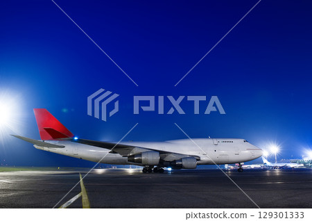 The plane stands at the airport at night 129301333
