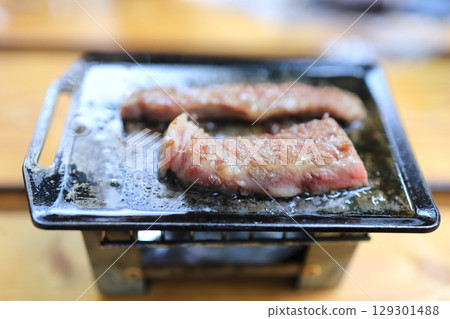 在迷你鐵板上烤的日本黑牛肉 在迷你鐵板上烤的日本黑牛肉 129301488