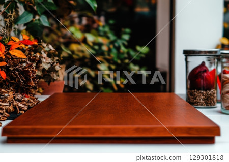 Wooden table ready for culinary creations in a cozy kitchen surrounded by plants 129301818