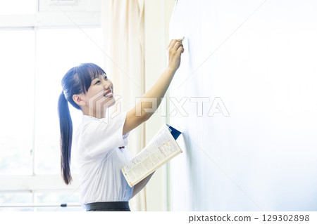 School girls who write letters on the blackboard 129302898
