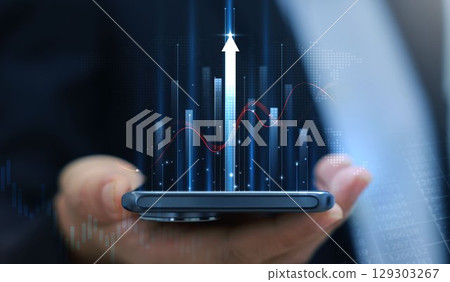 Businessman holding smartphone with glowing stock market chart and upward arrow. Financial growth, investment success, fintech, and trading technology concept. business stock market. Businessman holding smartphone with glowing stock market chart and upward arrow. Financial growth, investment success, fintech, and trading technology concept. business stock market. 129303267
