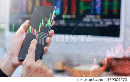 Businessman holding smartphone with glowing stock market chart and upward arrow. Financial growth, investment success, fintech, and trading technology concept. business stock market. Businessman holding smartphone with glowing stock market chart and upward arrow. Financial growth, investment success, fintech, and trading technology concept. business stock market. 129303270