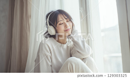 A woman listening to music with headphones 129303325