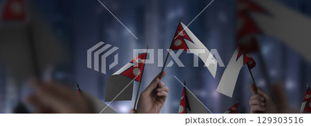 Nepal flags in their hands on a blurred urban background Nepal flags in their hands on a blurred urban background 129303516