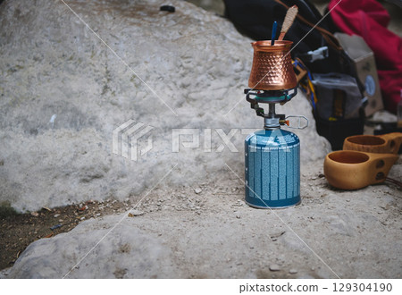 Portable Gas Stove Setup with Copper Pot on Outdoor Rock Surface Portable Gas Stove Setup with Copper Pot on Outdoor Rock Surface 129304190