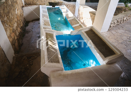 Natural Stone Structure Featuring a Vintage Clean Water Trough Under Natural Light 129304233
