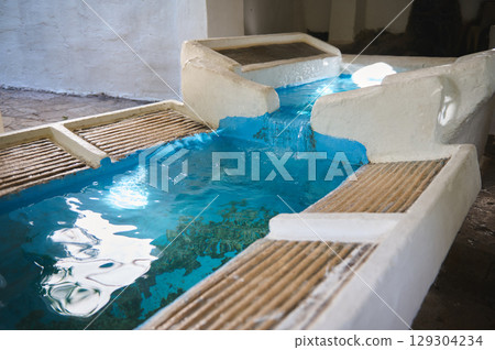 Vibrant Flowing Water in a Structured Pool Amid Rustic Surroundings Vibrant Flowing Water in a Structured Pool Amid Rustic Surroundings 129304234