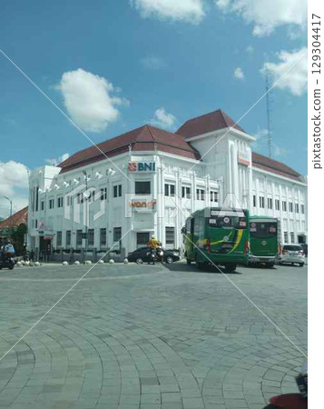 BNI 1946 Building, Yogyakarta. Exterior photograph of the Bank Negara Indonesia (BNI) building, a historic heritage site at Kilometer Zero point. This classic Art Deco-style building is a prominent la BNI 1946 Building, Yogyakarta. Exterior photograph of the Bank Negara Indonesia (BNI) building, a historic heritage site at Kilometer Zero point. This classic Art Deco-style building is a prominent la 129304417