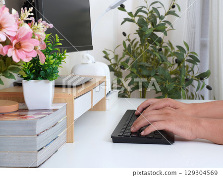 Modern workspace with hands typing on keyboard 129304569