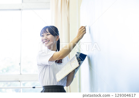 School girls who write letters on the blackboard 129304617