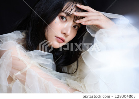 深色背景中身著禮服的年輕女子的奢華美容時尚肖像 129304803