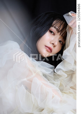 Luxury beauty fashion portrait of young woman in dress on dark background Luxury beauty fashion portrait of young woman in dress on dark background 129304806