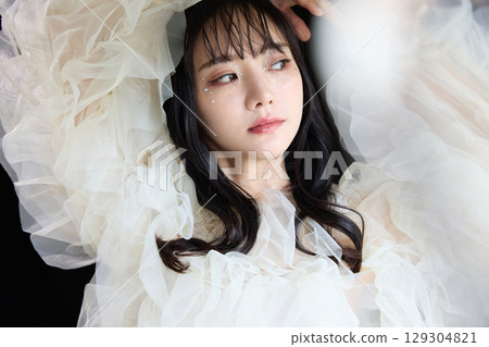 深色背景中身著禮服的年輕女子的奢華美容時尚肖像 129304821