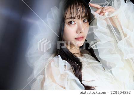 深色背景中身著禮服的年輕女子的奢華美容時尚肖像 129304822