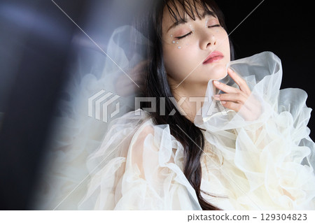 深色背景中身著禮服的年輕女子的奢華美容時尚肖像 深色背景中身著禮服的年輕女子的奢華美容時尚肖像 129304823
