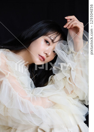 Luxury beauty fashion portrait of young woman in dress on dark background Luxury beauty fashion portrait of young woman in dress on dark background 129304856