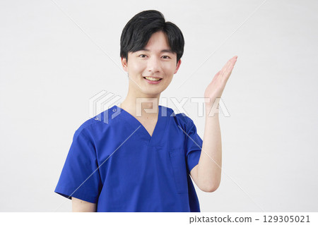 Doctor, nurse, dentist, caregiver, man pointing to the right with palm, white background Doctor, nurse, dentist, caregiver, man pointing to the right with palm, white background 129305021