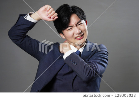 Businessman stiff shoulders black background Businessman stiff shoulders black background 129305028