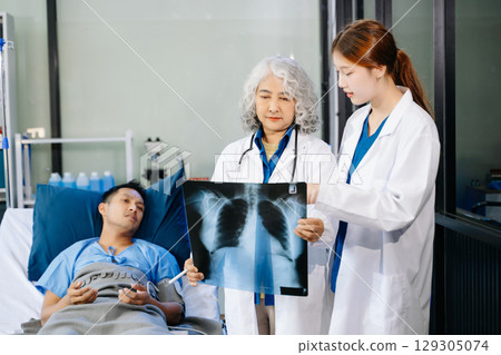 Hospital Ward Male and Male Professional Asian Doctors Talk with a Patient, Give Health Care Advice, Hospital Ward Male and Male Professional Asian Doctors Talk with a Patient, Give Health Care Advice, 129305074