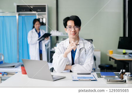 Doctor analyzing patient data on tablet in clinical lab. Medical professional in hospital with laptop, blood samples 129305085