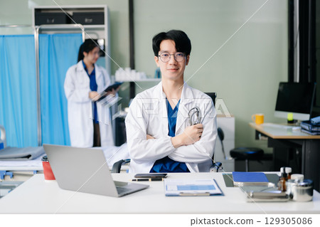 Doctor analyzing patient data on tablet in clinical lab. Medical professional in hospital with laptop, blood samples 129305086