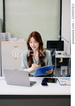 Business woman using tablet and laptop for doing math finance on an office desk, tax, report, accounting, 129305421