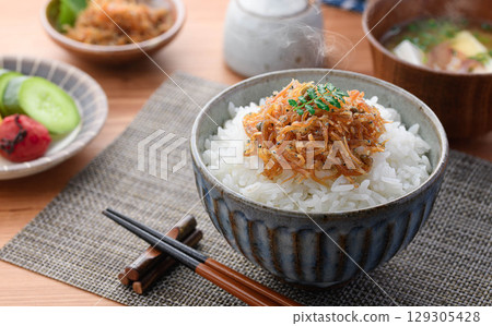 Steaming white rice with dried baby sardines and Japanese pepper. A perfect dish for a Japanese breakfast, rice accompaniment, or bento lunch box. Steaming white rice with dried baby sardines and Japanese pepper. A perfect dish for a Japanese breakfast, rice accompaniment, or bento lunch box. 129305428