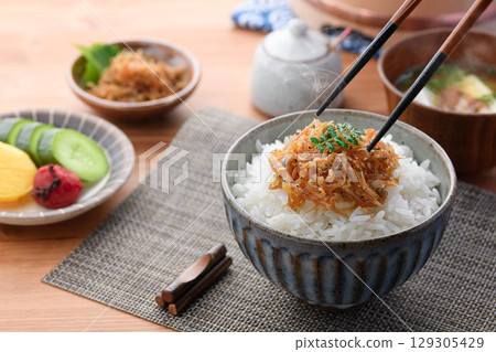 Steaming white rice with dried baby sardines and Japanese pepper. A perfect dish for a Japanese breakfast, rice accompaniment, or bento lunch box. Steaming white rice with dried baby sardines and Japanese pepper. A perfect dish for a Japanese breakfast, rice accompaniment, or bento lunch box. 129305429