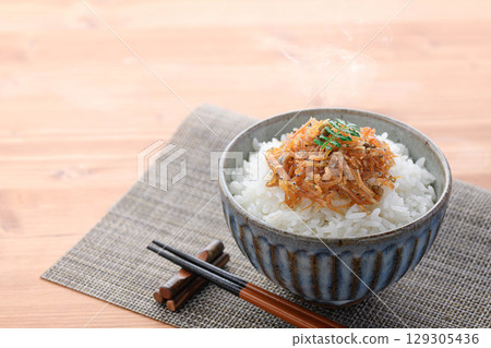 Steaming white rice with dried baby sardines and Japanese pepper. A perfect dish for a Japanese breakfast, rice accompaniment, or bento lunch box. Steaming white rice with dried baby sardines and Japanese pepper. A perfect dish for a Japanese breakfast, rice accompaniment, or bento lunch box. 129305436