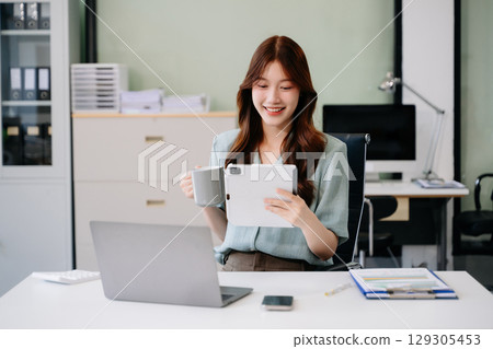 Business woman using tablet and laptop for doing math finance on an office desk, tax, report, accounting, Business woman using tablet and laptop for doing math finance on an office desk, tax, report, accounting, 129305453