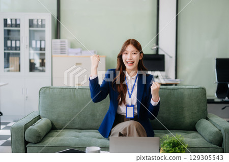 Young Asian working on laptops and tablets in a stylish office. Perfect for creativity, remote work, modern lifestyle, 129305543