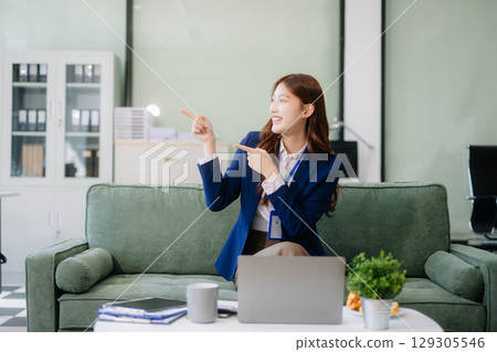 Businesswomen brainstorming in a cozy office, collaborating with a laptop and notebook 129305546