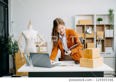 Startup small business SME, Entrepreneur owner woman using smartphone or tablet taking receive and checking online purchase shopping order Startup small business SME, Entrepreneur owner woman using smartphone or tablet taking receive and checking online purchase shopping order 129305598