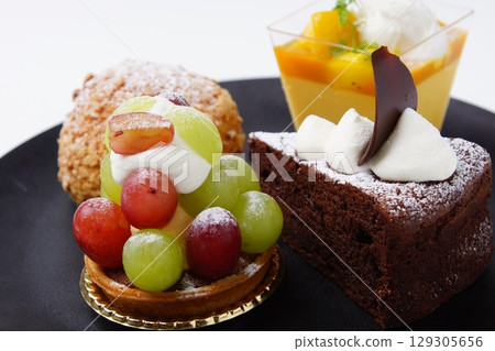 Fruit tart, chocolate, cream puff, mango cake Fruit tart, chocolate, cream puff, mango cake 129305656