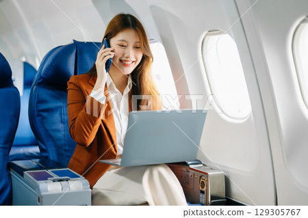 Young Asian executive excels in first class, multitasking with digital tablet, laptop and smartphone Young Asian executive excels in first class, multitasking with digital tablet, laptop and smartphone 129305767