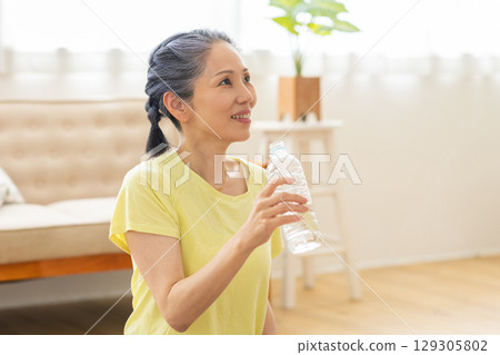 A woman drinking water 129305802