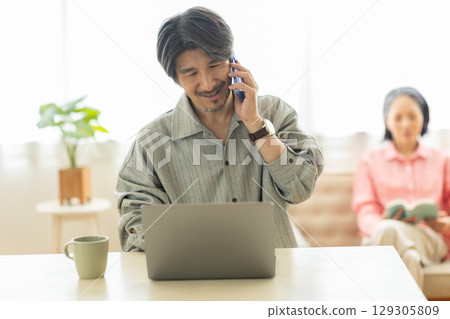 A man who calls while watching a computer 129305809