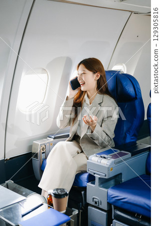 Young Asian executive excels in first class, multitasking with digital tablet, laptop and smartphone. for finance, travel, and lifestyle 129305816