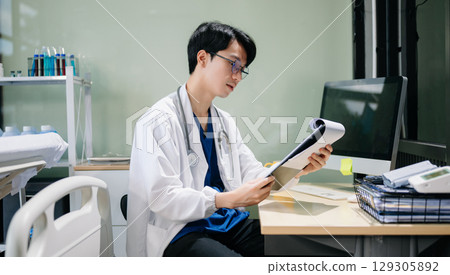 Doctor analyzing patient data on tablet in clinical lab. Medical professional in hospital with laptop, blood samples Doctor analyzing patient data on tablet in clinical lab. Medical professional in hospital with laptop, blood samples 129305892