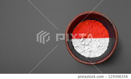 Closeup view of the red and white colors of the Indonesian national flag with a black wall background. Celebrate Indonesia Independence Day. Concept of Kemerdekaan Indonesia 129306356