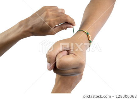 Human hands tying colorful rakhis on the wrist, isolated over a white background, celebrating the bond of love and protection. Concept of the Raksha Bandhan festival 129306368
