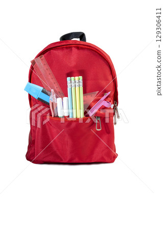 The backpack opens with the arrangement of school supplies isolated over a white background. Copy space. Concept of Back to School 129306411
