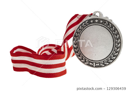 Closeup view of the silver award medal suspended from a red and white striped ribbon isolated over a white background. Copy space. Symbol of achievement, recognition, or competition 129306439