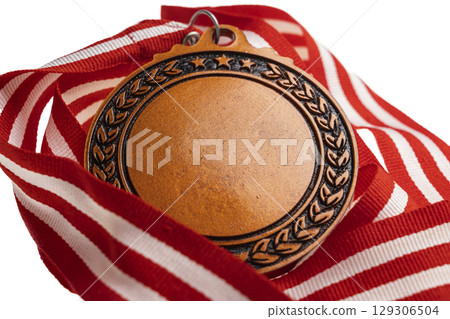 Closeup view of the bronze award medal suspended from a red and white striped ribbon isolated over a white background. Copy space. Symbol of achievement, recognition, or competition Closeup view of the bronze award medal suspended from a red and white striped ribbon isolated over a white background. Copy space. Symbol of achievement, recognition, or competition 129306504