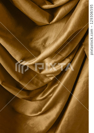 Golden satin silk with crumpled abstract texture background. Material textile surface. Copy space Golden satin silk with crumpled abstract texture background. Material textile surface. Copy space 129306595