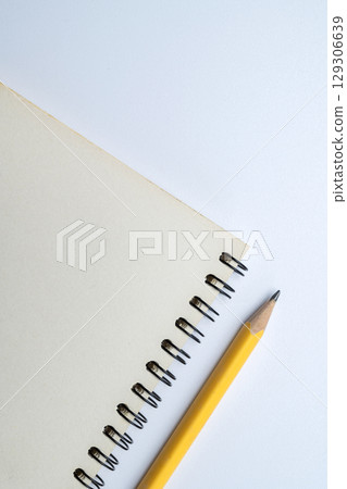 Empty notebook and a wooden pencil isolated over a white background. Copy space. Concept of Back to School 129306639