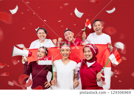 Indonesian southeast asian people celebrate Indonesia Independence Day on the 17th of August by holding a megaphone and the Indonesian national flag. Concept of Kemerdekaan Indonesia 129306969