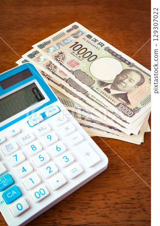 Money and a calculator on a desk 129307022