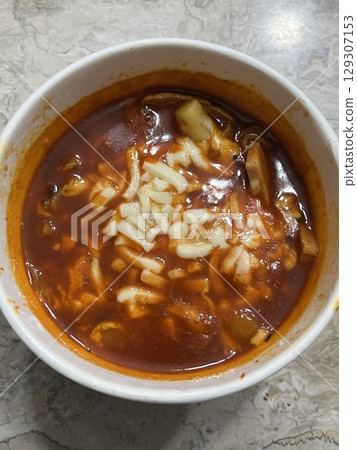Spicy Korean tteokbokki with chewy rice cakes in a vibrant red sauce, topped with sesame seeds and green onions. A popular street food known for its addictive flavor and satisfying texture. Spicy Korean tteokbokki with chewy rice cakes in a vibrant red sauce, topped with sesame seeds and green onions. A popular street food known for its addictive flavor and satisfying texture. 129307153