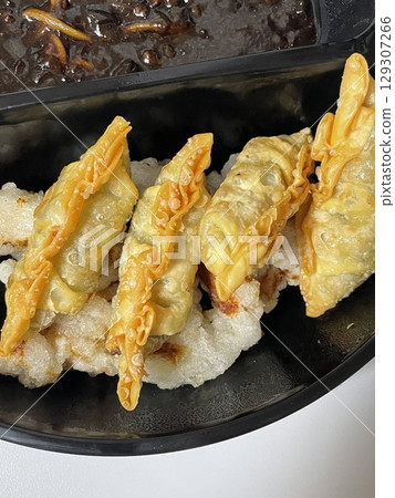 Tangsuyuk, a Korean-Chinese dish featuring crispy, deep-fried pork or beef pieces, served with a sweet and sour sauce made from vinegar, sugar, and fruit. A perfect balance of tangy and savory flavors 129307266